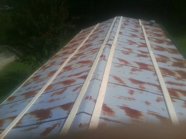 Rusted metal roof panels with new wood purlins before replacement — Storm Damage Roof Repair in Brooklyn by Roofing Brothers