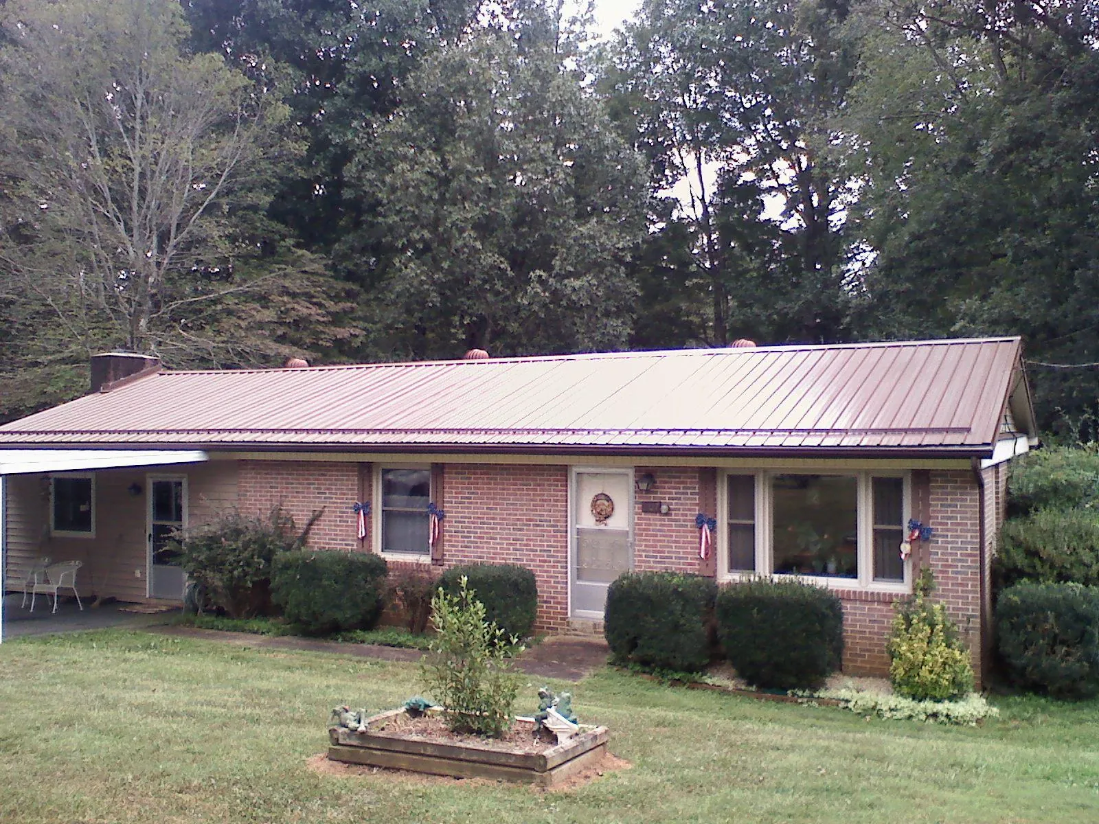 Bronze metal roof on a brick ranch home with a carport in Brooklyn
